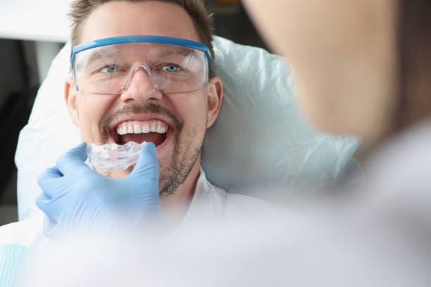 Dentist fitting oral appliance for TMJ treatment in NYC